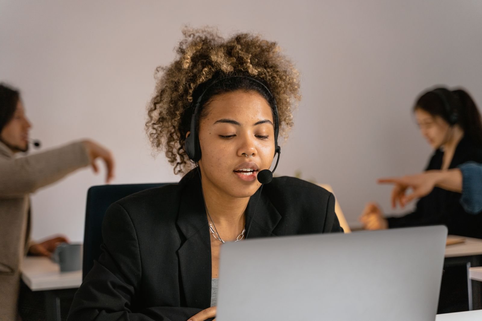 A multilingual agent with a headset at her laptop