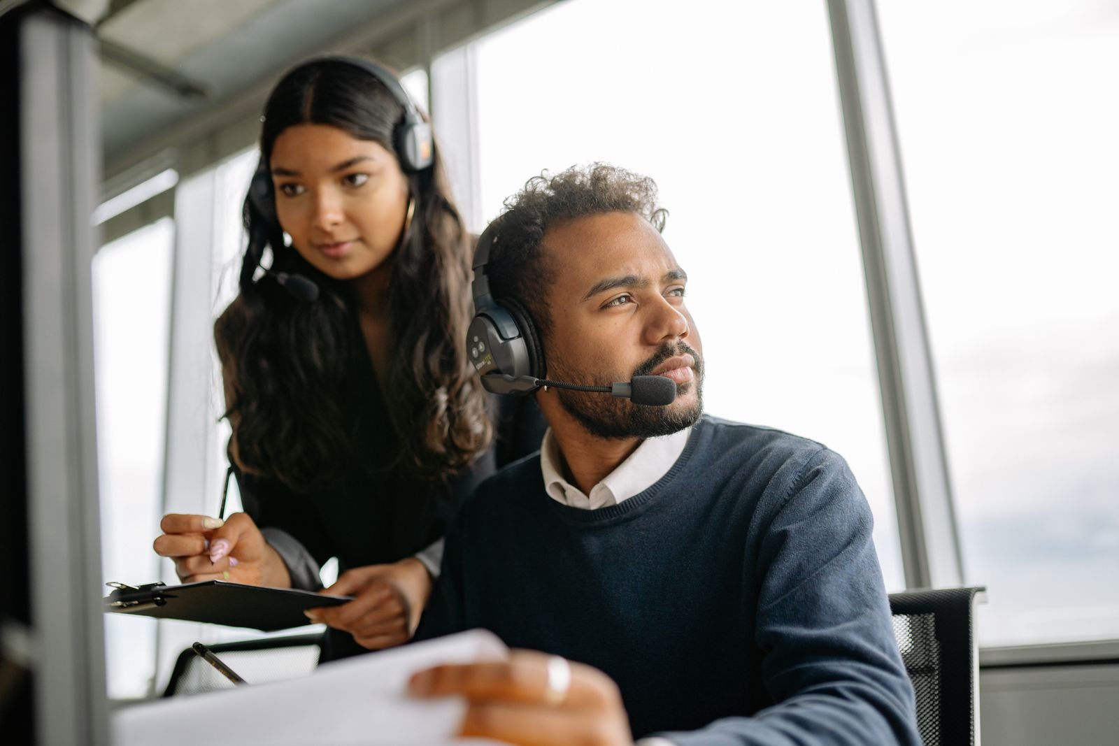Two interpreters with headsets reviewing a document together