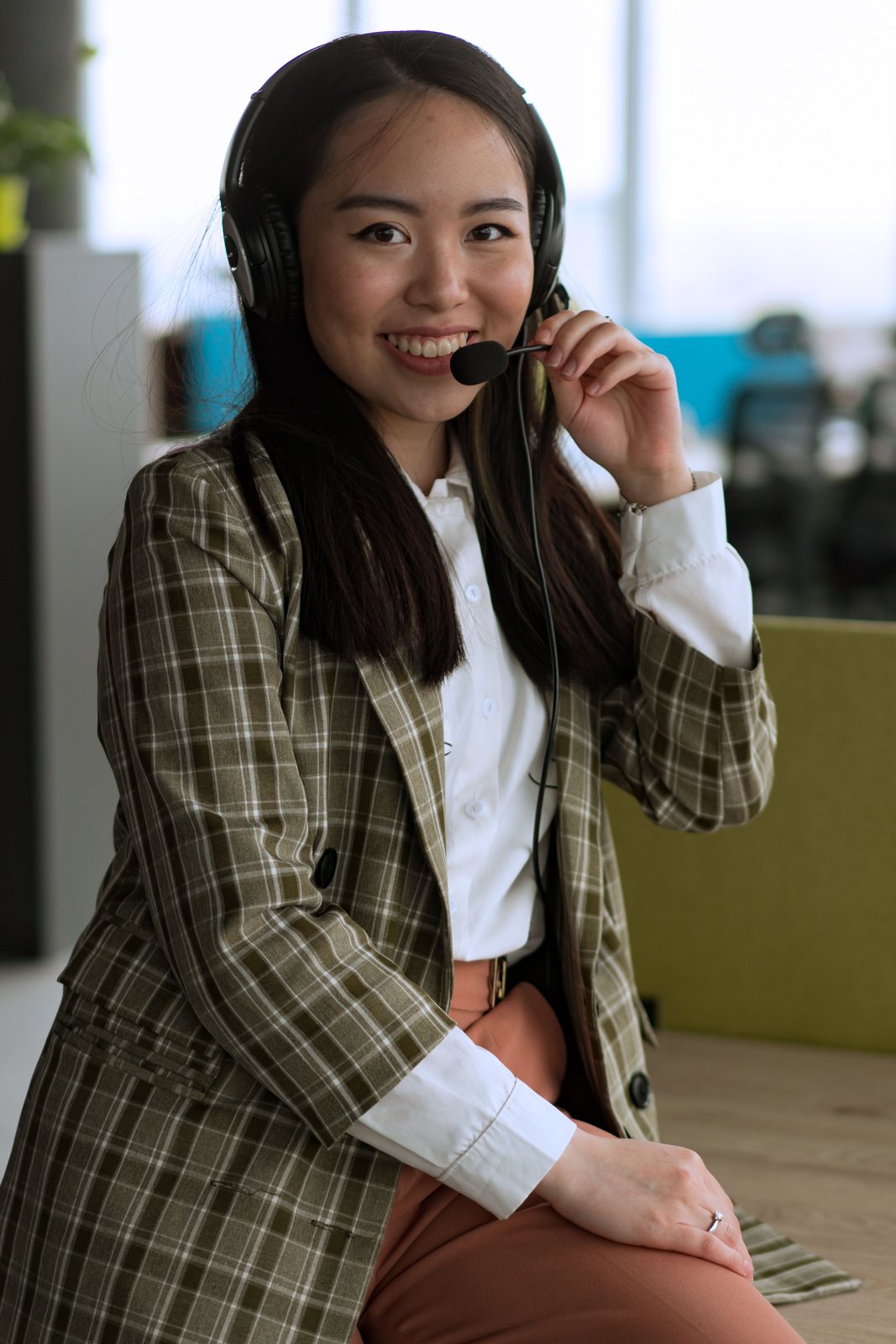 A smiling interpreter speaking into her headset microphone