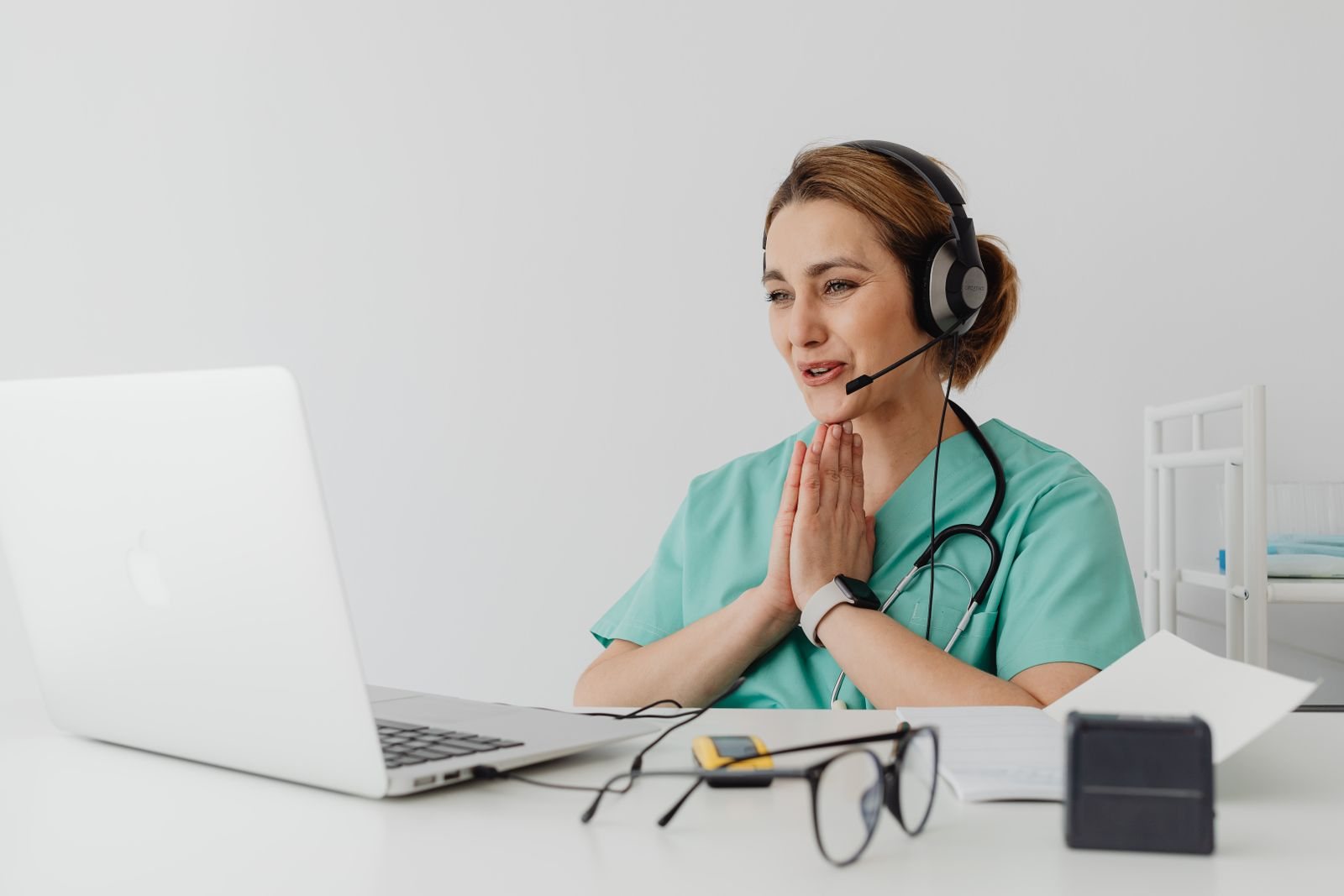 A clinician with a headset on a video call